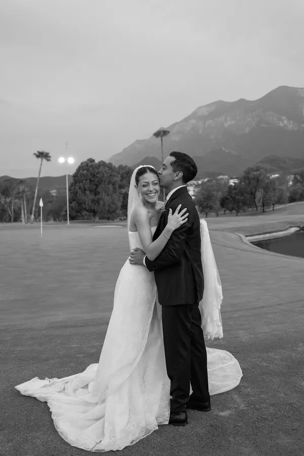 Denisse and Sergio embracing in front of the mountains, in black and white